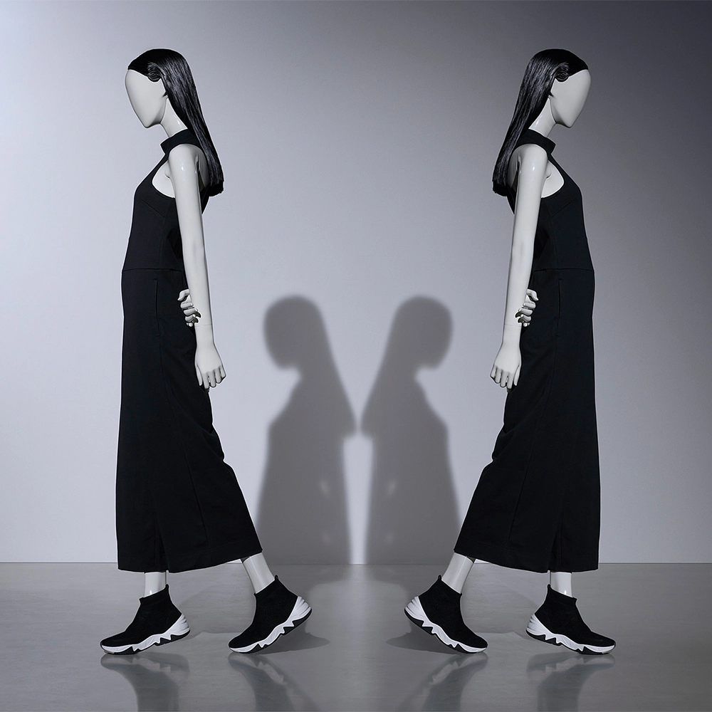Two female blend poses in symmetry walking away from each other with black hair and clothes