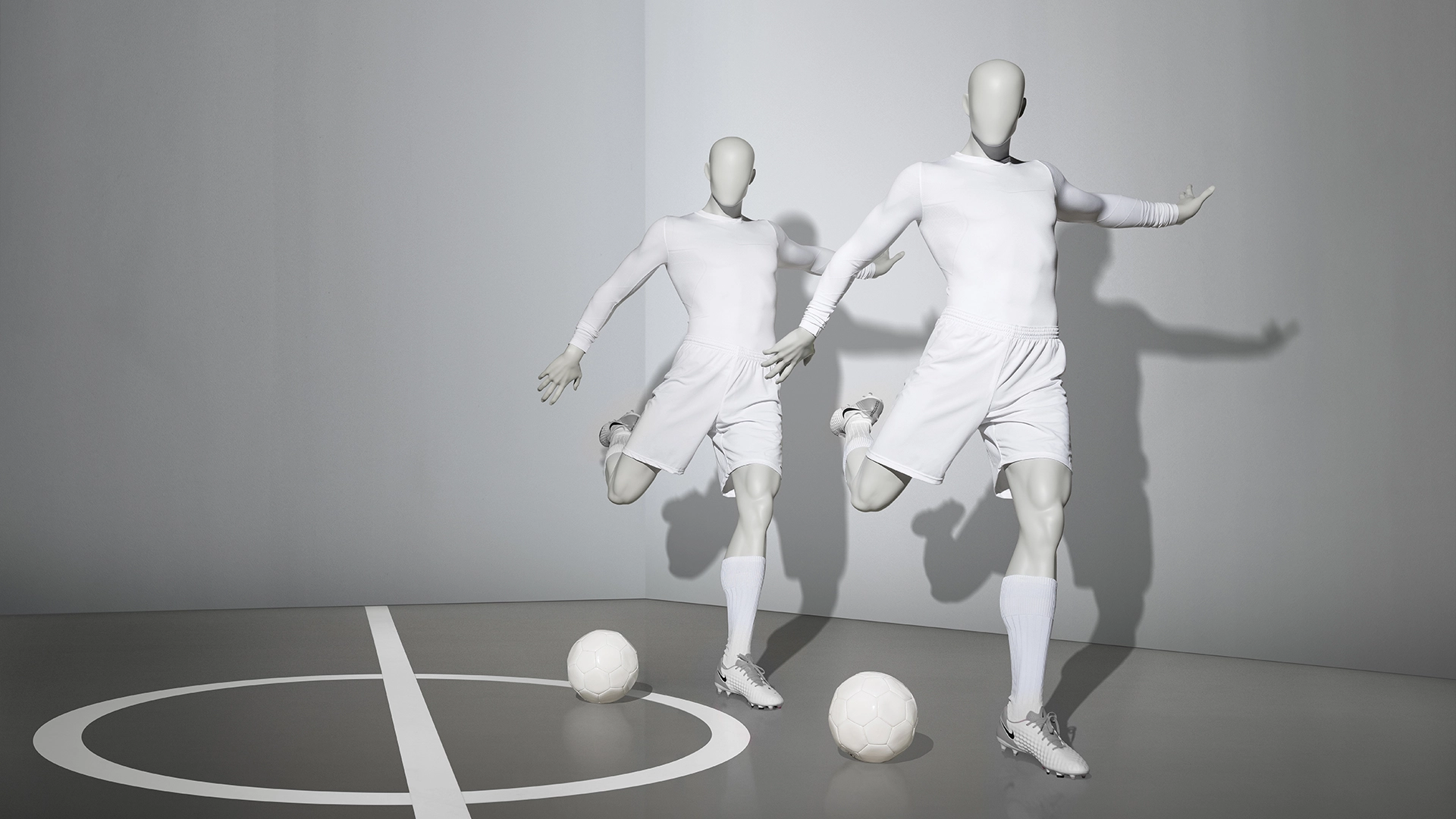 a pair of male sport mannequins in football shooting poses